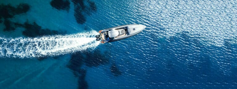 Aerial drone photo of inflatable speed boat cruising with high speed in the deep blue Aegean sea