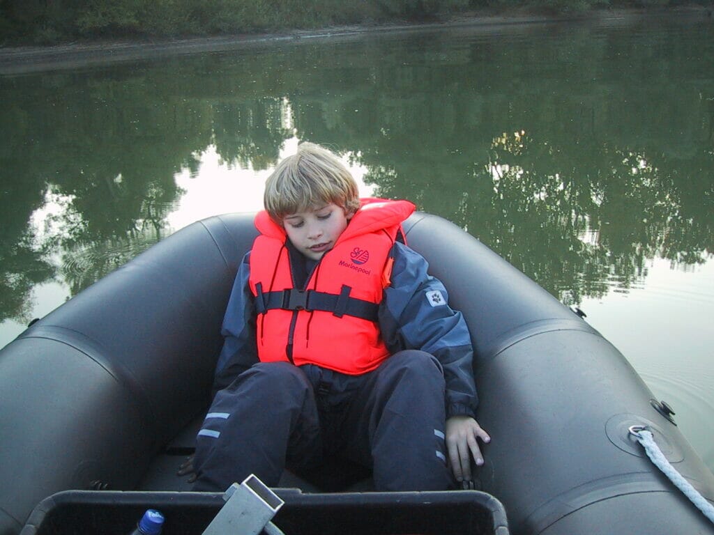 young boy sitting in the bow of an inflatable boat