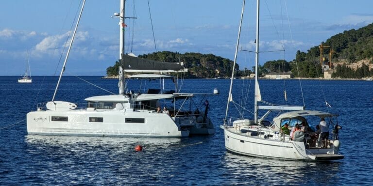 monohull and catamaran anchoring in the Dalmatian Sea in Croatia next to each other