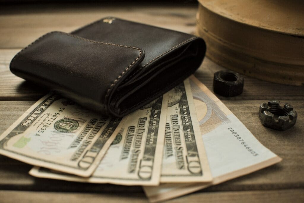 wallet with money on a wooden background
