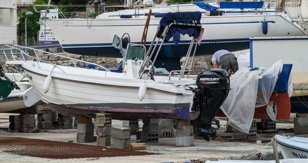 boats taken out of the water to be repaired in the marina. In the focus is a GRP console boat